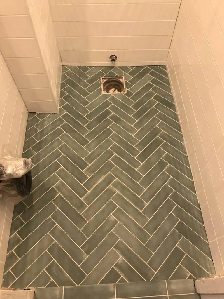 Herringbone gulvlægning med grønne fliser i vådrum under renovering Fliser badeværelse