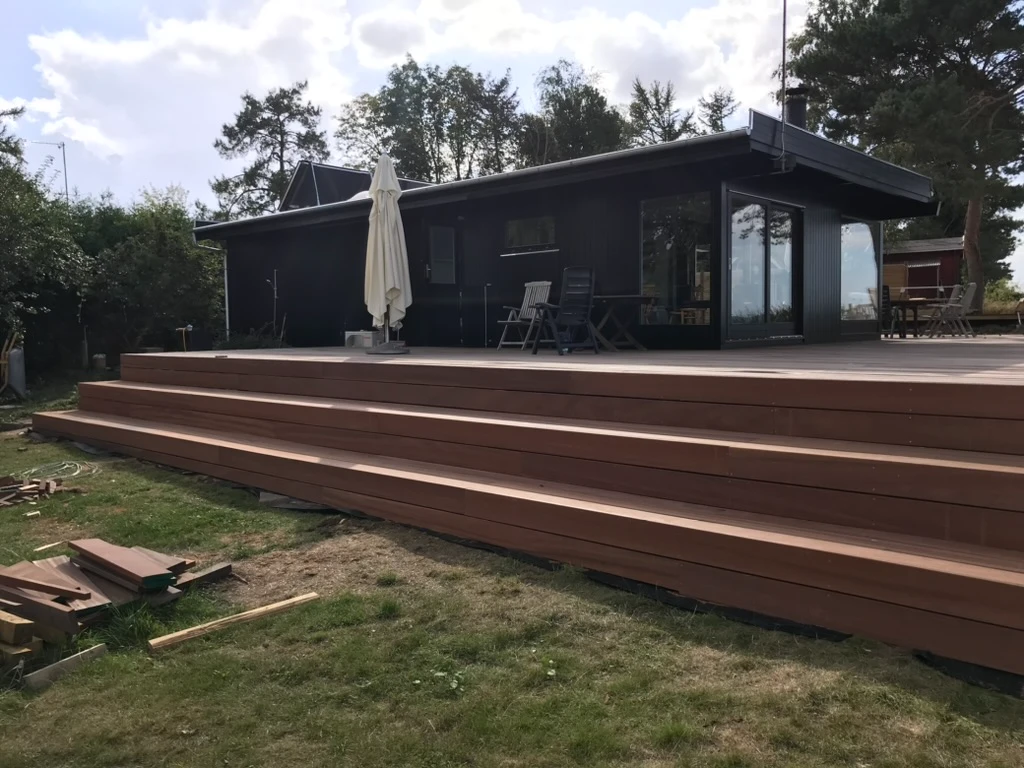 Stor ny træterrasse med brede trin foran moderne sommerhus
